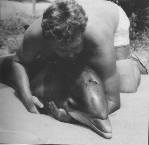 George Gray holds April, an orphaned calf. Gray was a critical member of the team that successfully nursed her to health. 